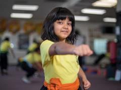 Child punching and smiling in a kids' martial arts class