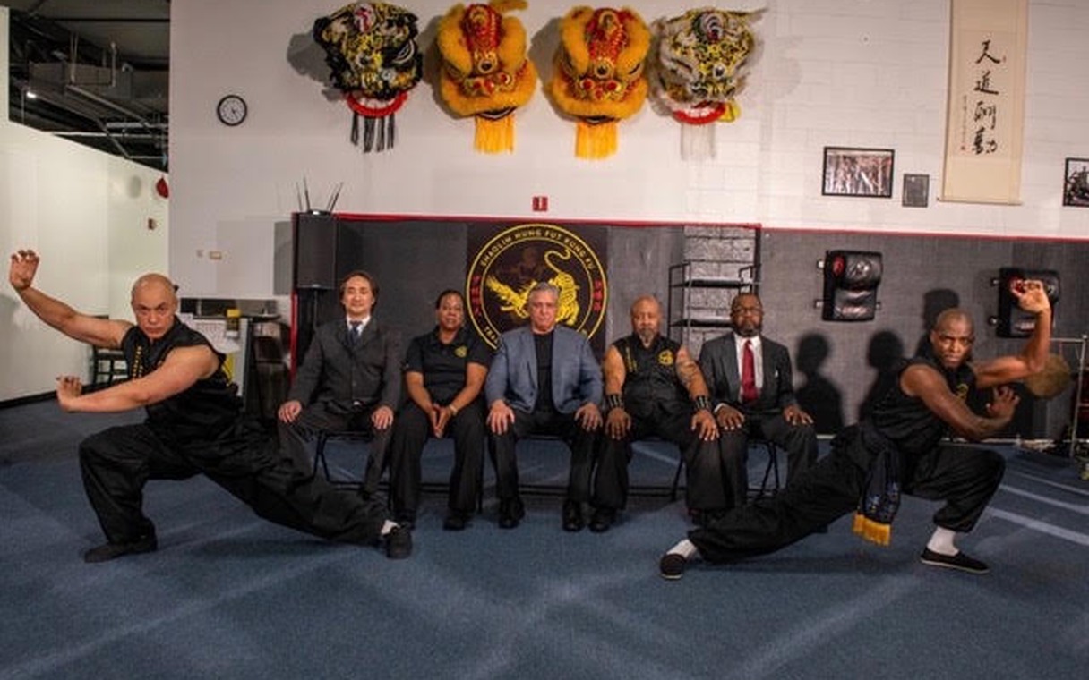 The 9th-generation masters of the Hung Fut system with two newly promoted masters holding low stances at either end of the group